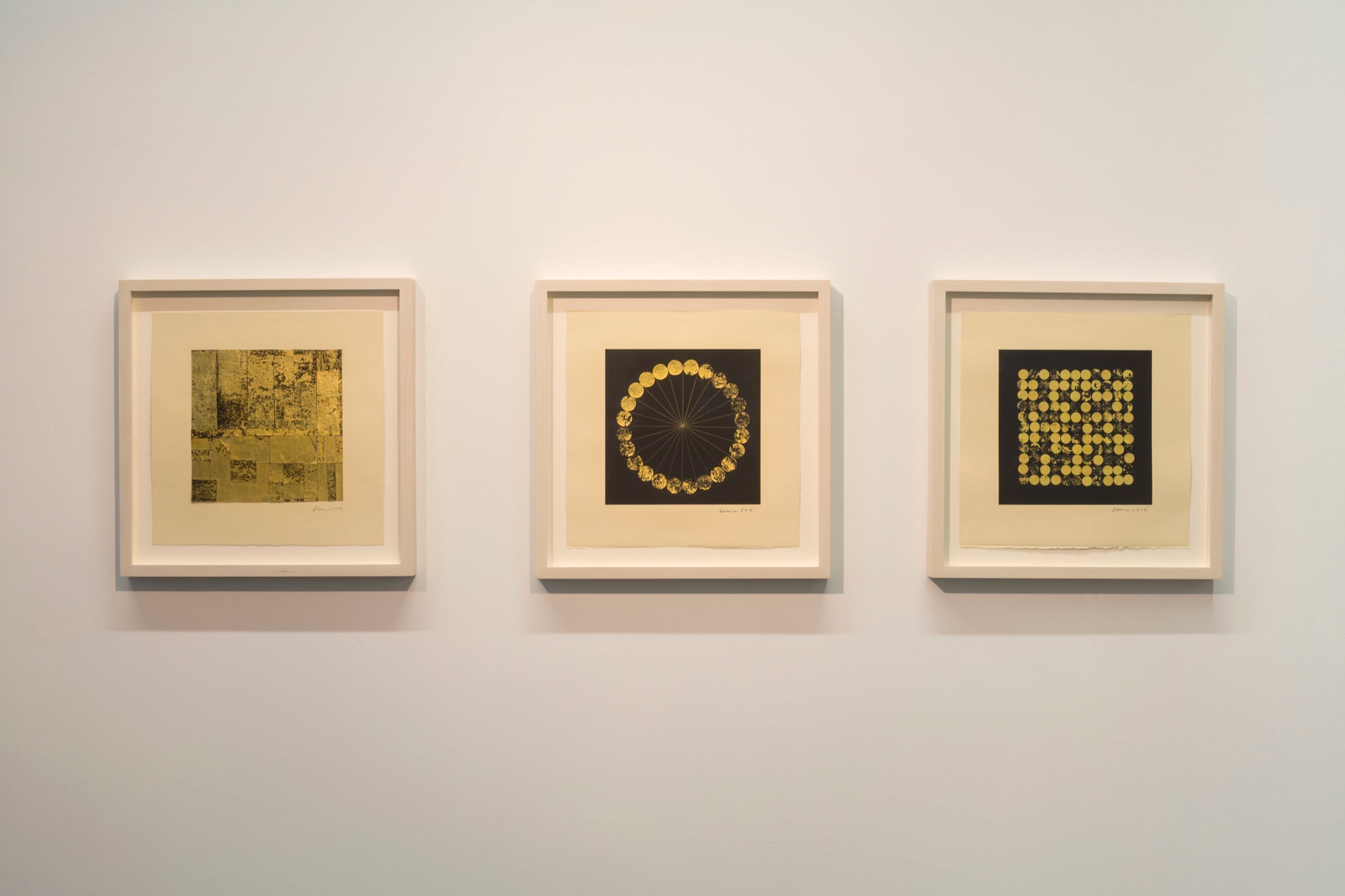 Installation view of Life Lines in Paris, with three framed black-and-gold works arranged across a white gallery wall