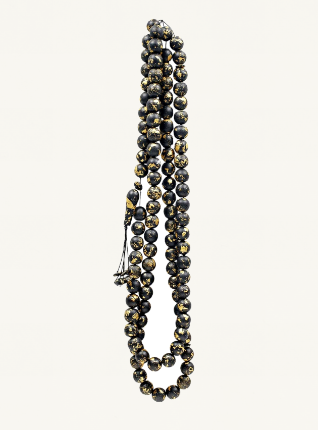 Tasbih, 2011, Zarina’s long strand of dark prayer beads flecked with gold and suspended against a pale ground